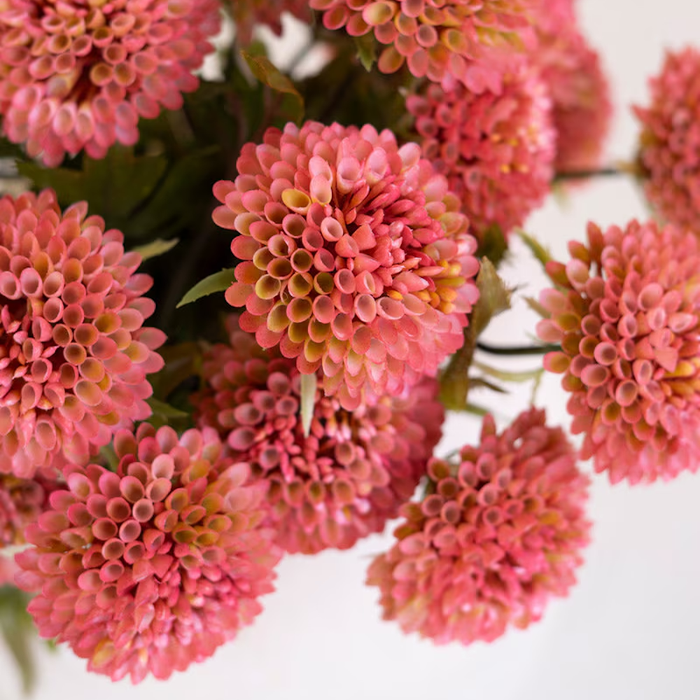 Bundle of artificial blush pink ball dahlias in a close-up view showing detailed, honeycomb-like round petals.