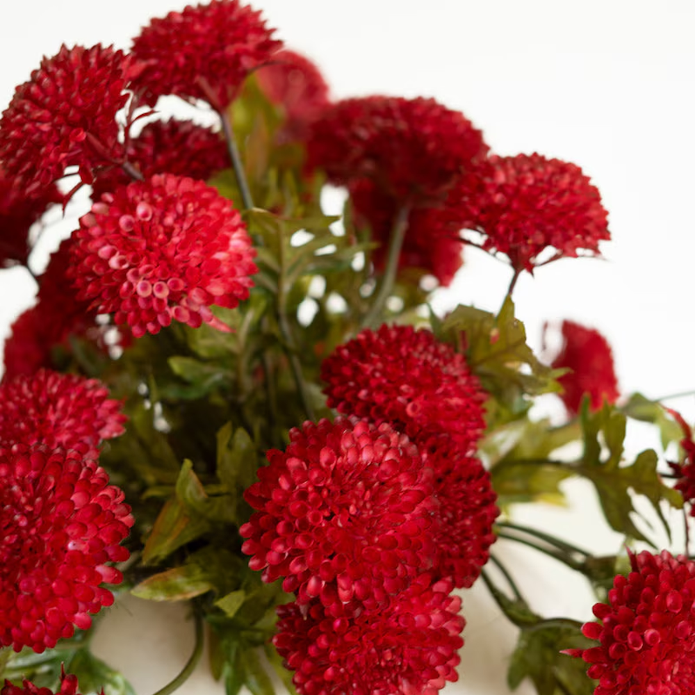 Detailed close-up of artificial deep red ball dahlias highlighting textured pom-pom blooms.