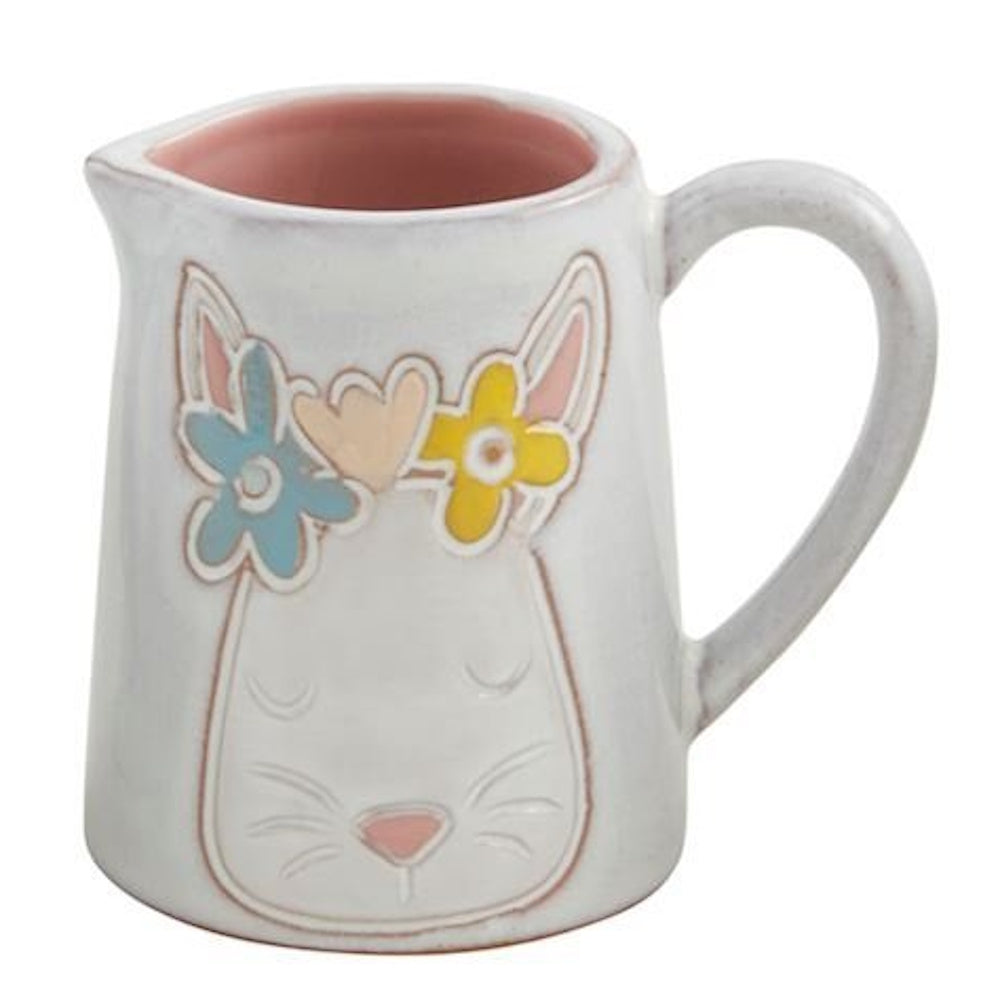 White ceramic pitcher featuring an embossed bunny face with a colorful flower crown and a pink interior.