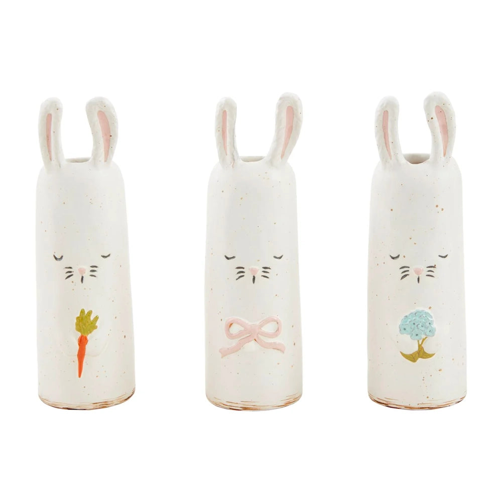 Three tall, white ceramic rabbit bud vases with painted details of a carrot, a pink bow, and a blue flower.