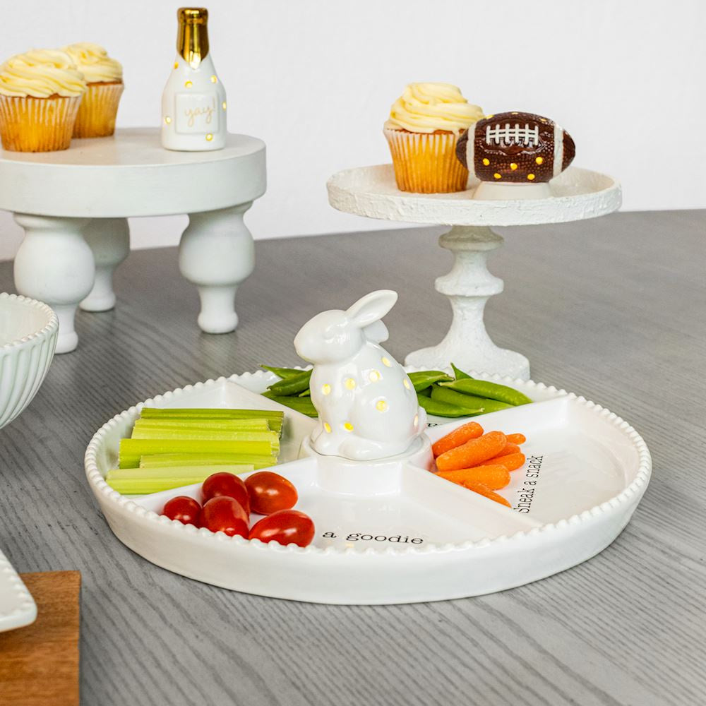 Ceramic bunny light-up sitter on a divided snack tray with vegetables, tomatoes, and cupcakes on a party table.