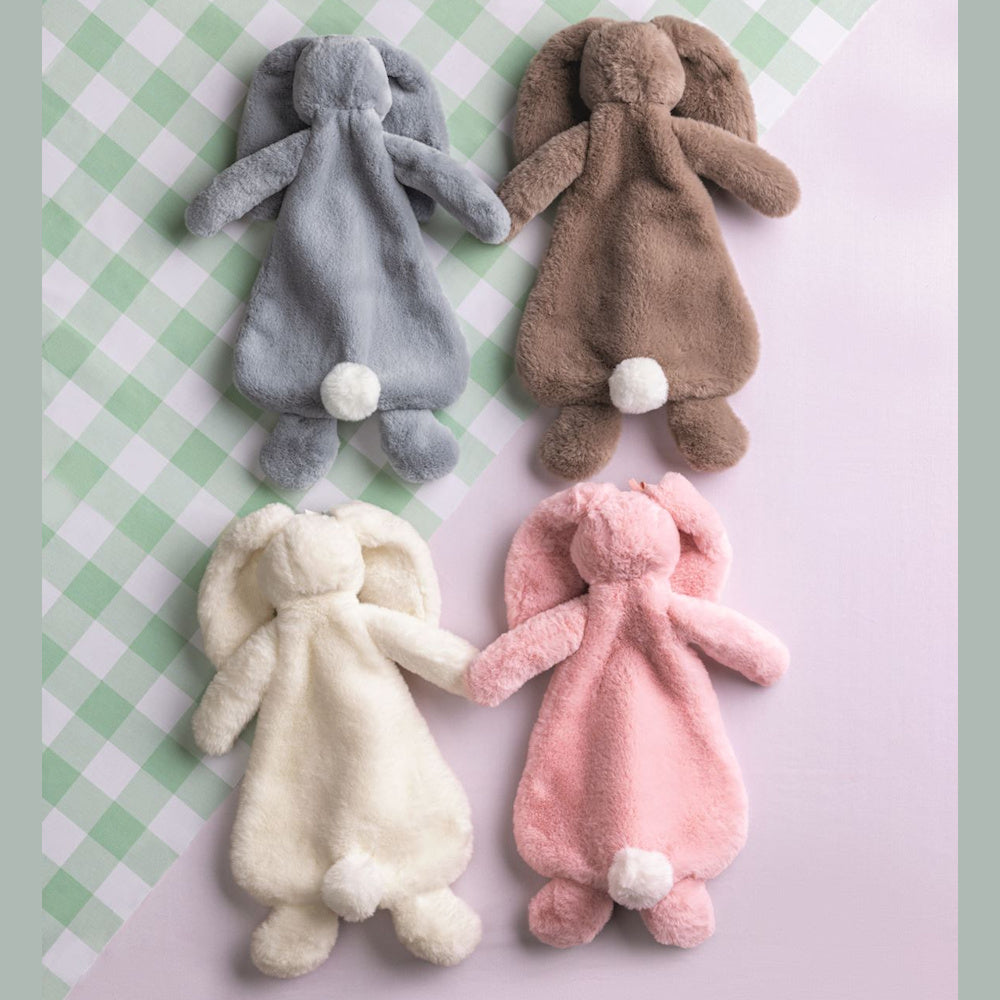 Four plush bunny security blankets in grey, brown, cream, and pink with soft white tails on a green gingham background.