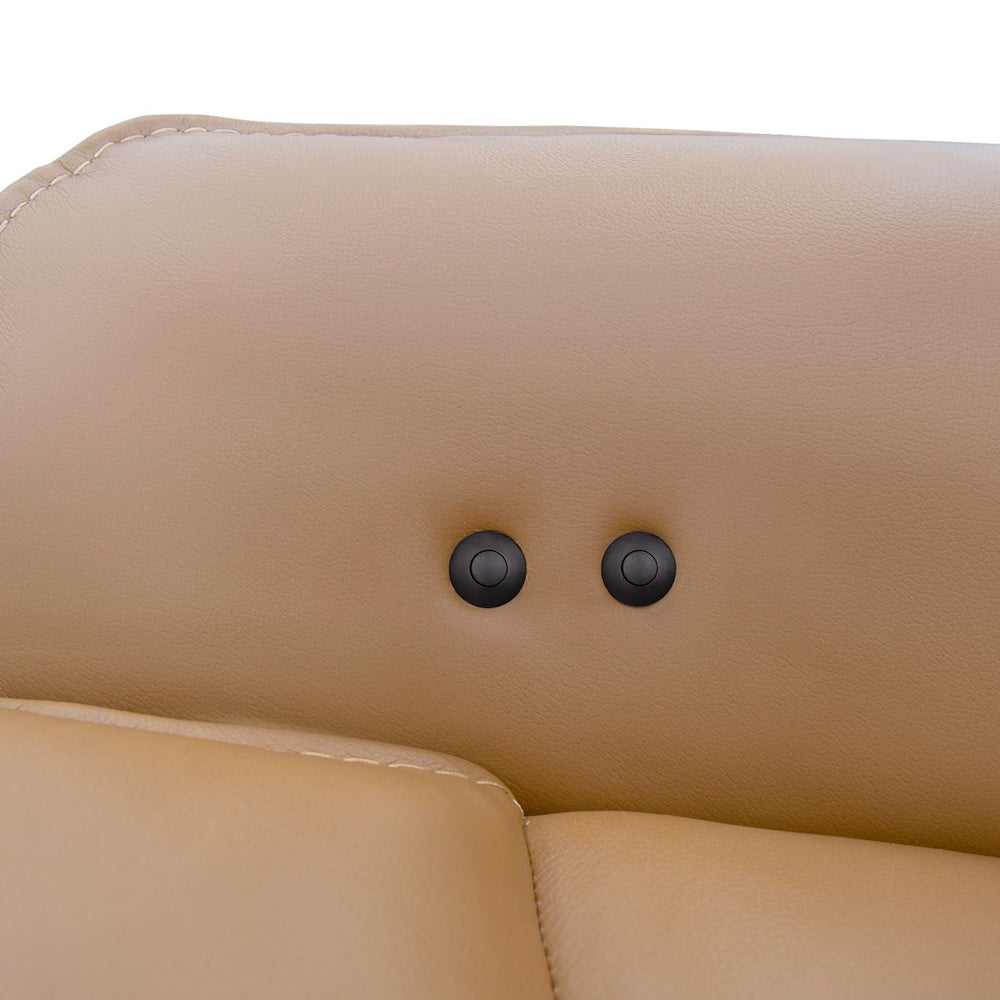 Close-up of two small black control buttons on the tan leather armrest of a chair.