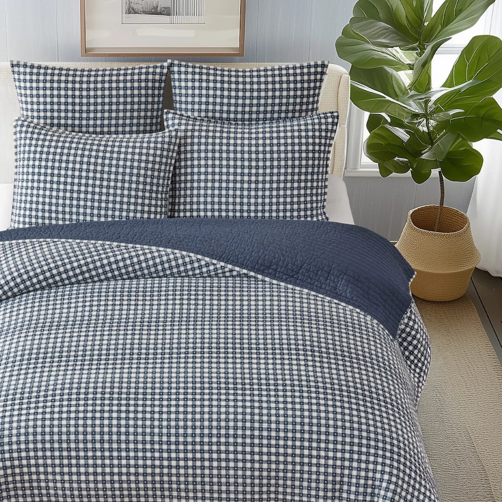 Navy blue and white gingham quilt set with matching shams, folded over with a solid blue reverse side.