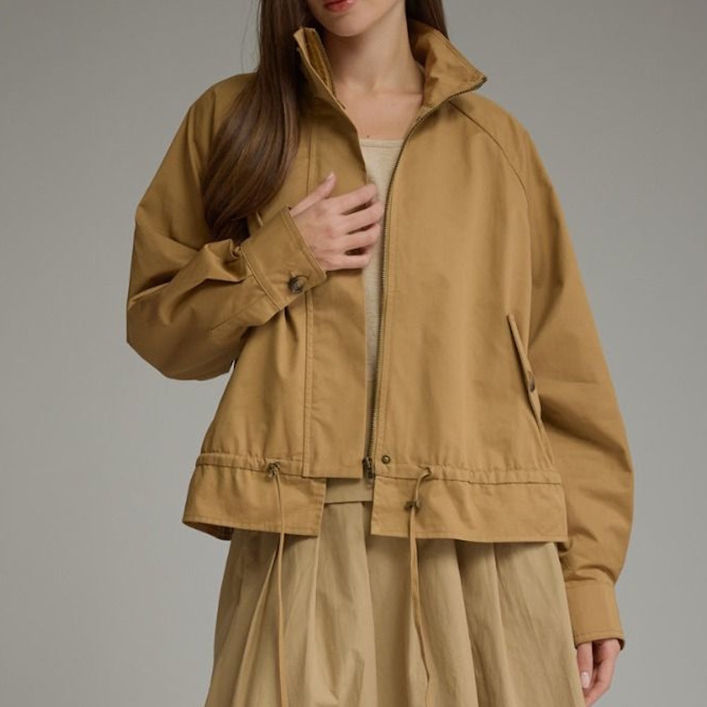 Full front view of a camel full-zip jacket featuring a high collar, raglan sleeves, and drawstring hem.