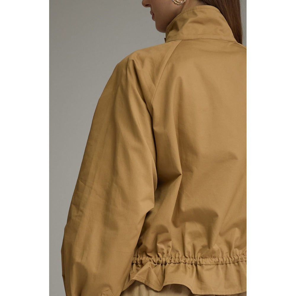 Back view of a camel jacket showing high stand collar and cinched drawstring hem detail.