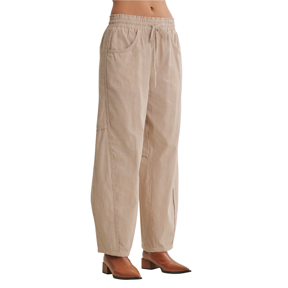 Beige striped relaxed-fit barrel pants with a drawstring waist, styled with brown boots.
