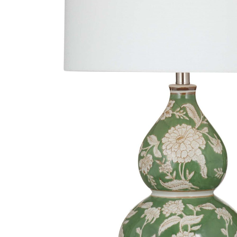 Green ceramic double gourd table lamp with white floral pattern and white drum shade.
