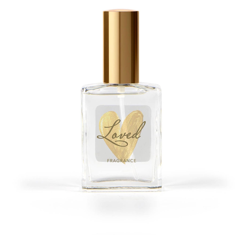 Clear glass perfume bottle with a gold cap and a label featuring a gold heart and the word "Loved."