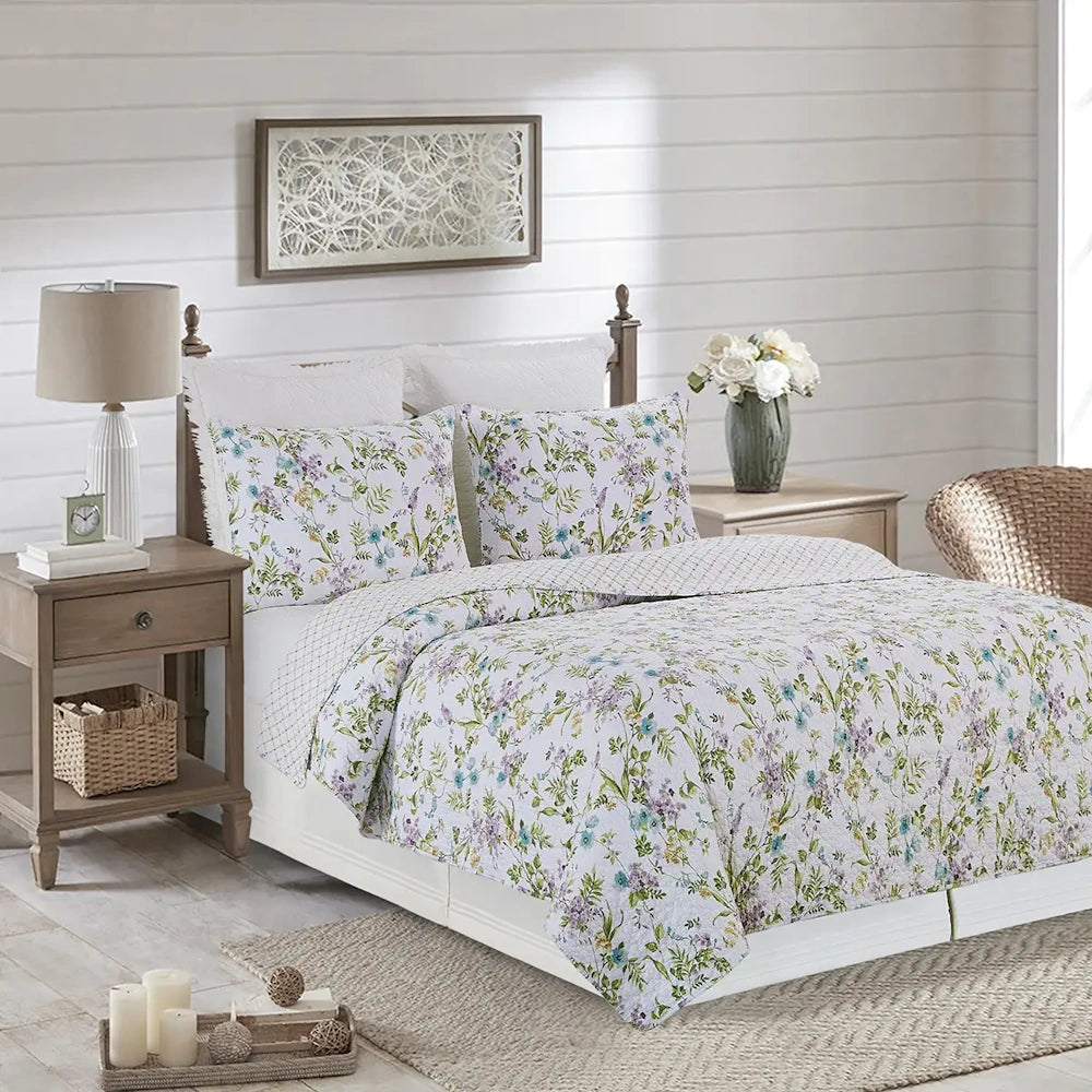 A bed with a white floral quilt and matching pillows in a bright, farmhouse-style bedroom.