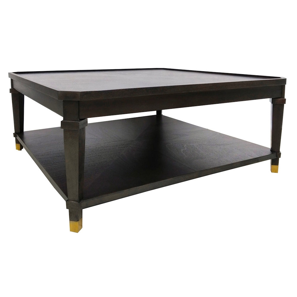 Modern dark wood square coffee table with lower storage shelf and gold brass capped tapered legs on a white background.