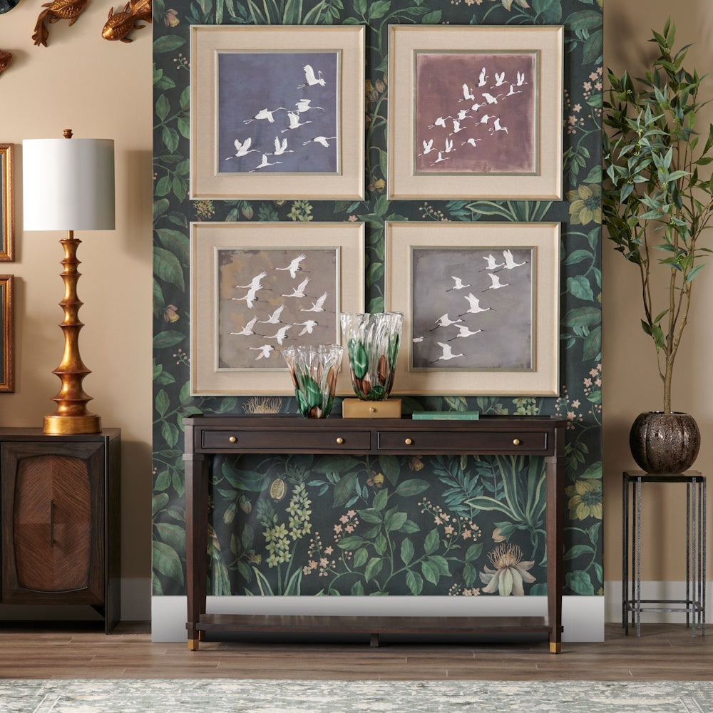 Modern entryway with dark wood console table, botanical wallpaper, and four framed crane bird art prints.