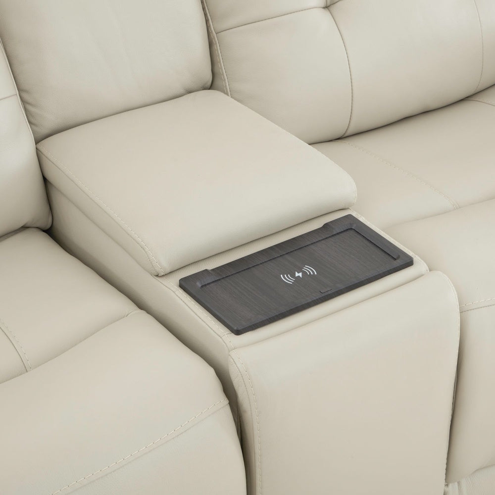 Close up of loveseat center console with wireless charging pad and padded armrest in cream leather upholstery.