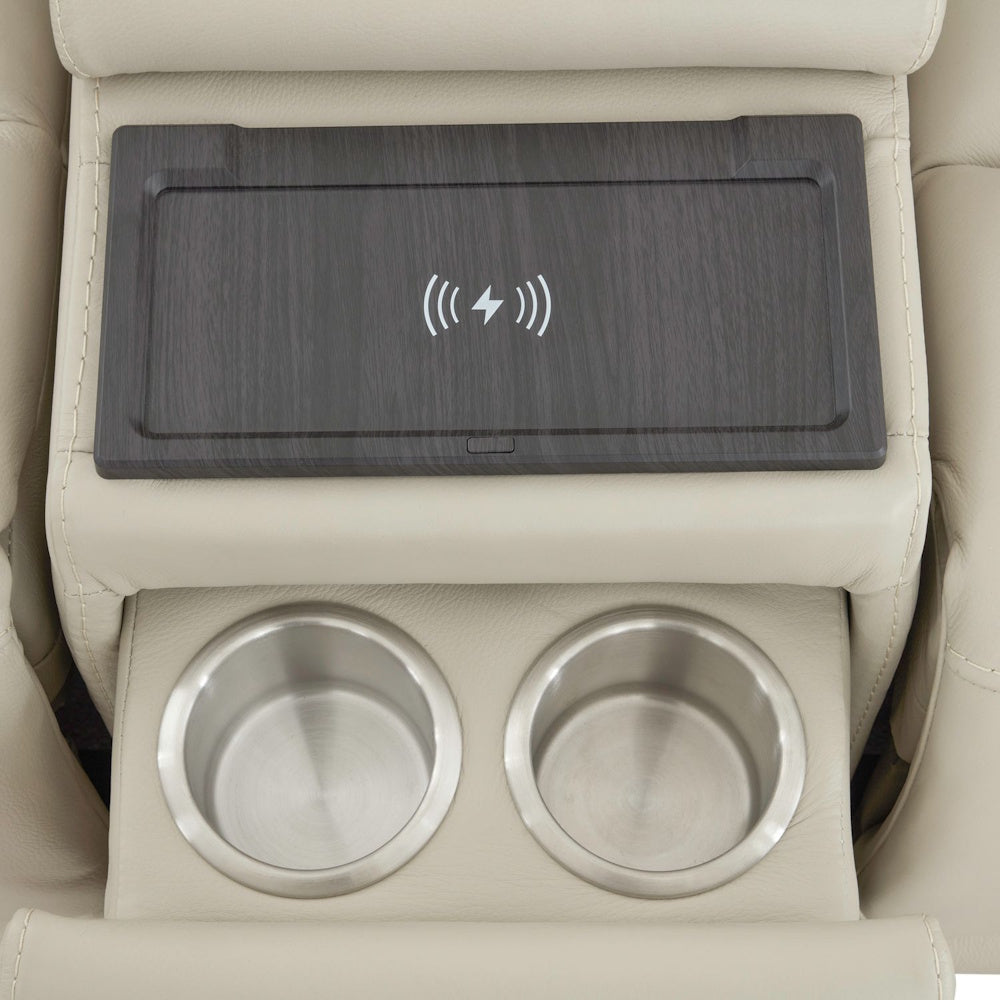 Close up of loveseat center console with dual stainless steel cup holders and wireless charging pad surface.
