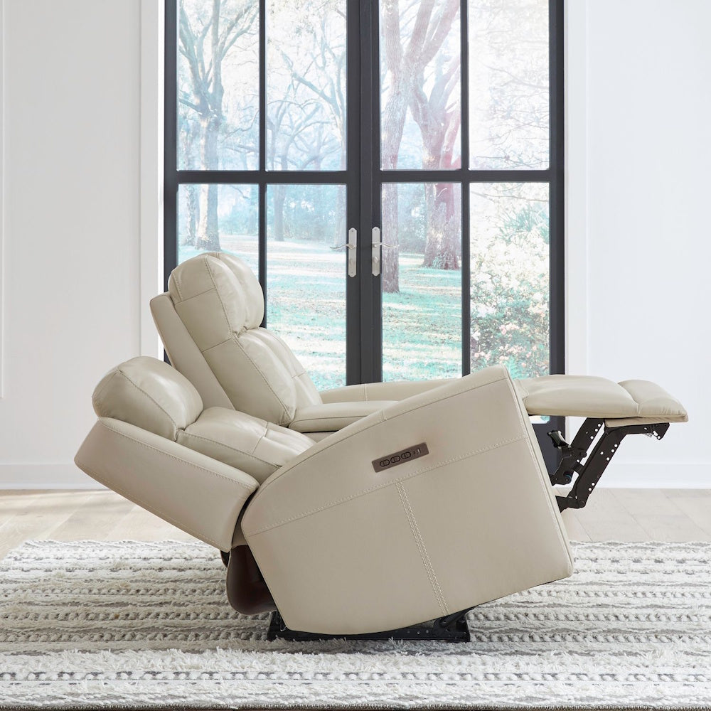 Side view of cream leather power reclining loveseat fully reclined, showcasing adjustable headrest and footrest positions.