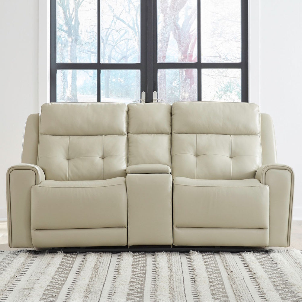 Cream leather power reclining loveseat with center console displayed in a bright modern living room setting.