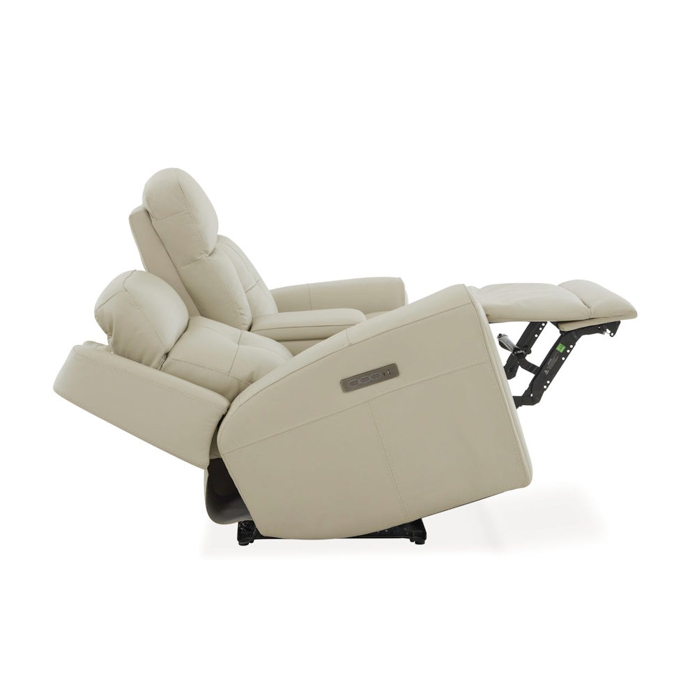 Side view of cream leather power reclining loveseat fully reclined with extended footrest and adjustable headrest support.