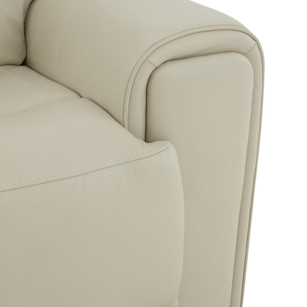 Cream leather sofa arm close up with plush cushioning, rounded profile and refined stitched detailing.
