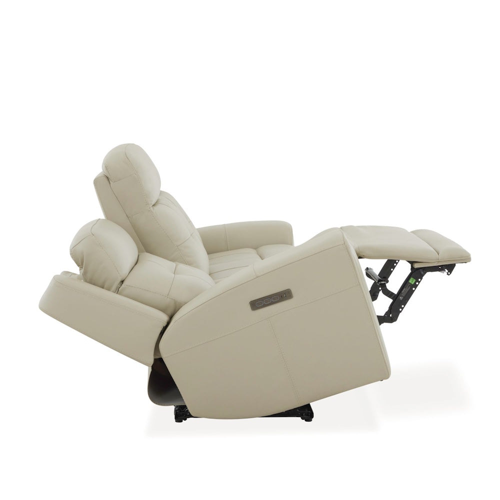 Cream leather power reclining sofa in reclined position with adjustable headrest, extended footrest and side controls.