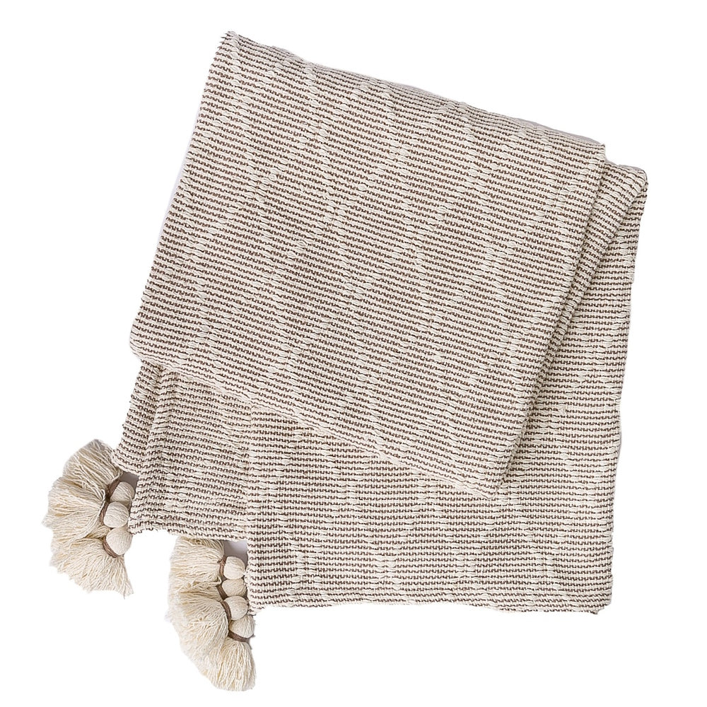 A folded, textured beige and brown woven throw blanket with decorative tassels on a white background.