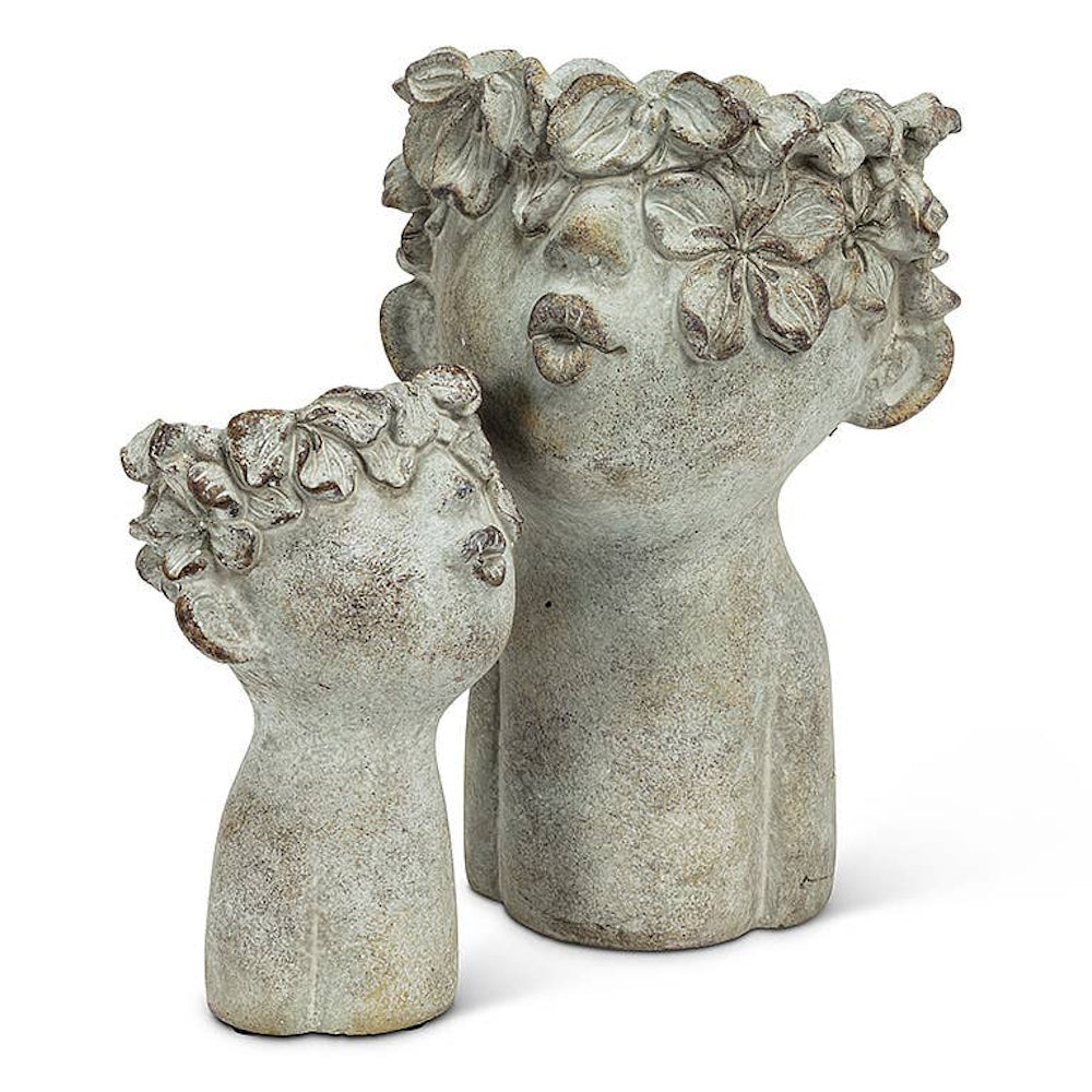 Two rustic cement head planters with floral crowns shaped with kissing lips, in small and large.