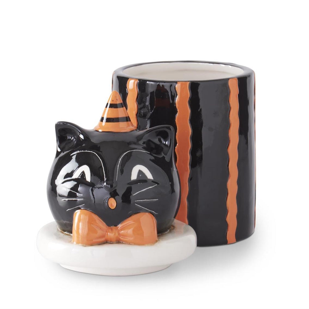 An open black cat ceramic canister with orange stripes and a lid shaped like a cat face on a white background.