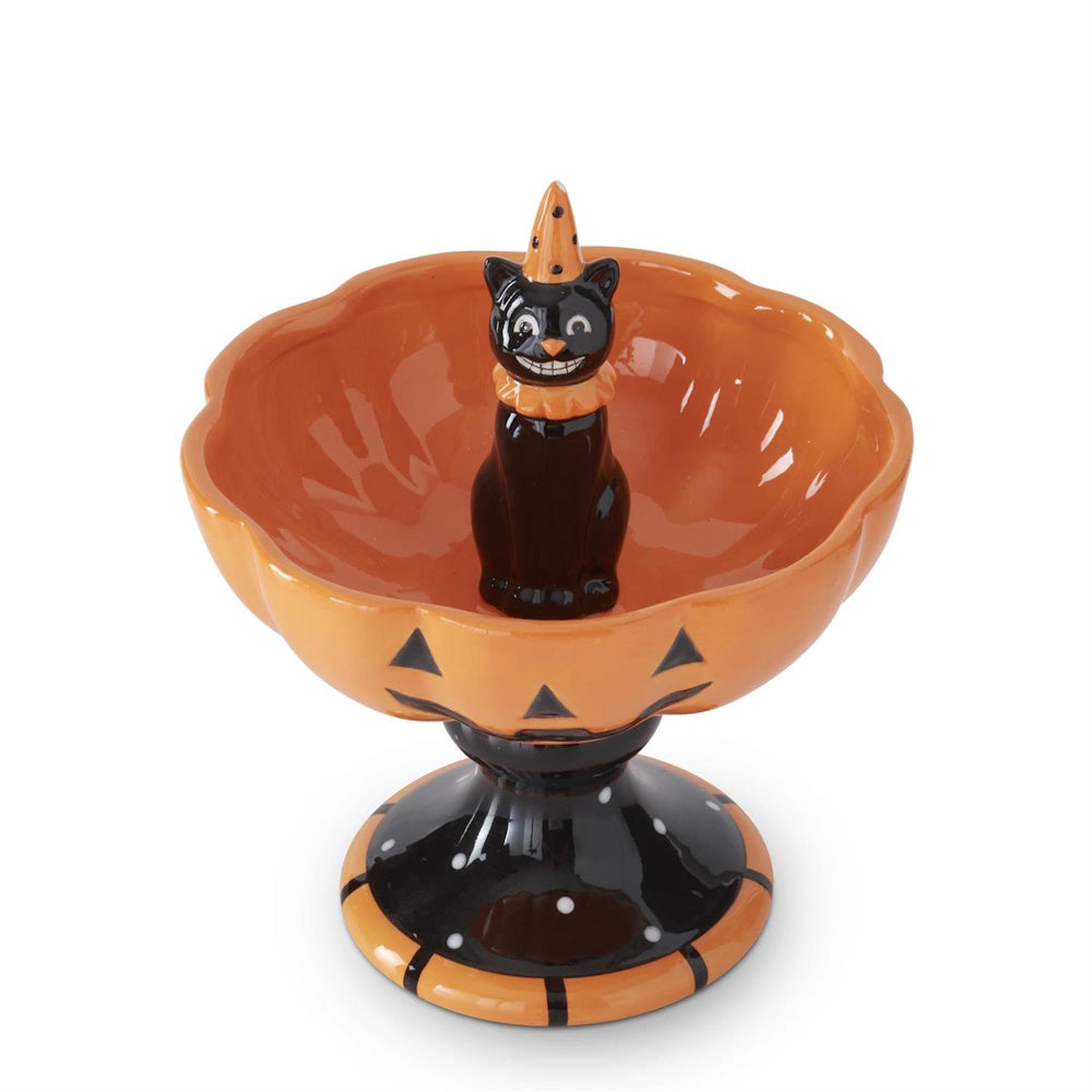 Orange jack-o'-lantern pedestal bowl with a black cat wearing a party hat in the center.