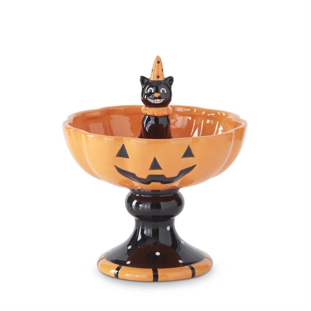 Ceramic Halloween jack-o'-lantern pedestal bowl with a smiling black cat figurine in the center.