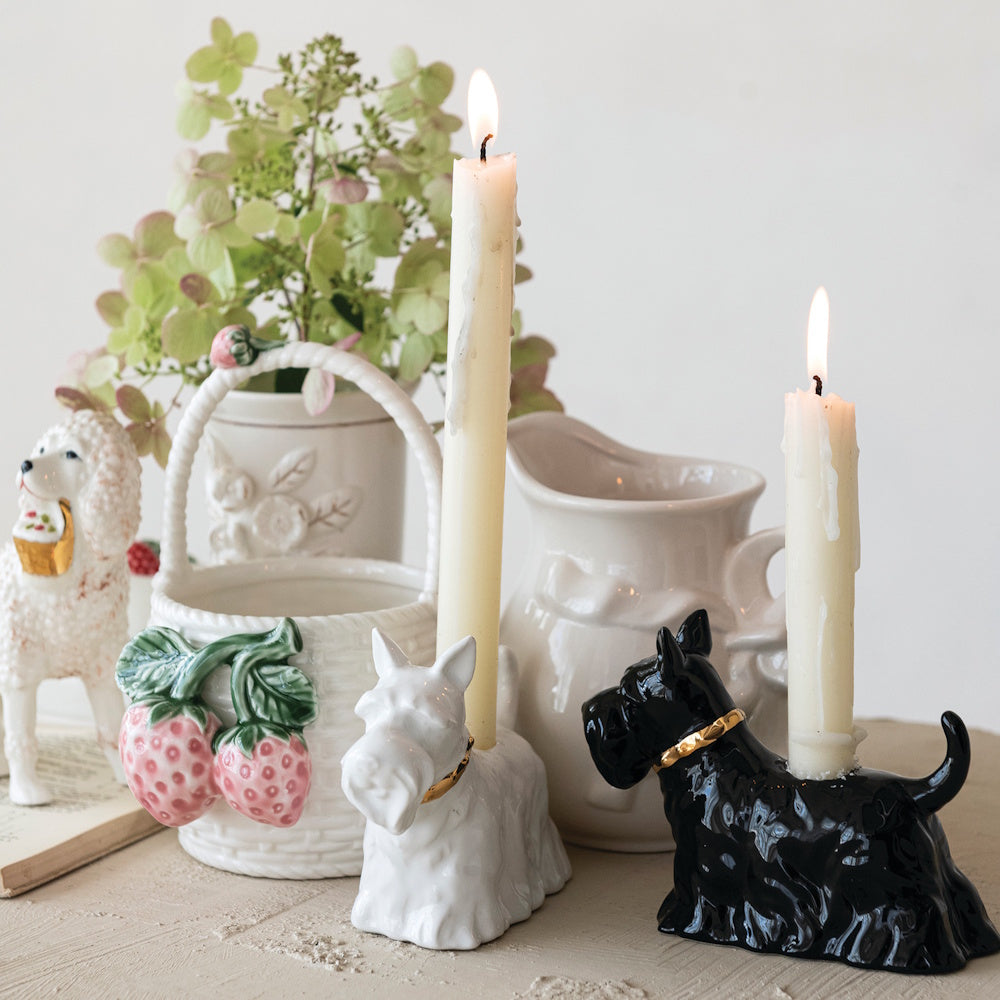 Black and white ceramic Scottie dog taper candle holders on a tabletop display.
