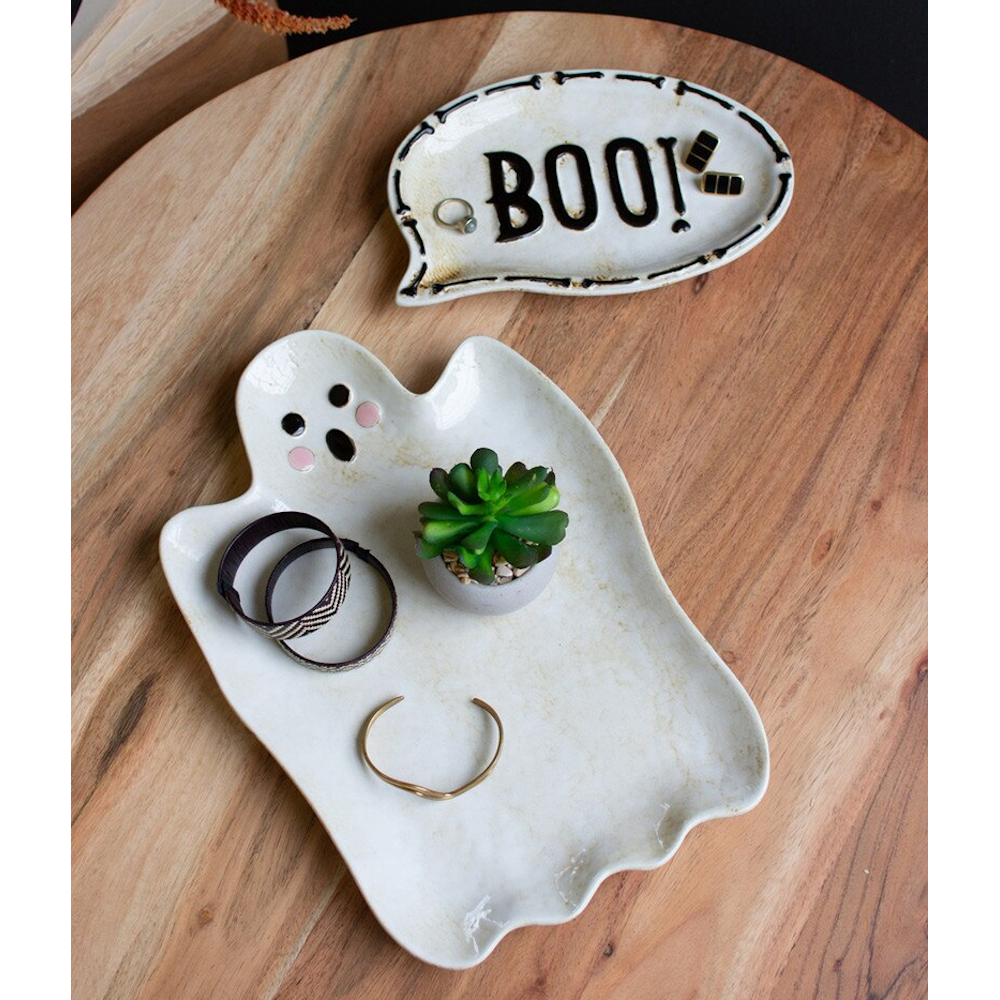 Ceramic ghost and "BOO!" speech bubble trinket dishes holding jewelry on a wooden table.