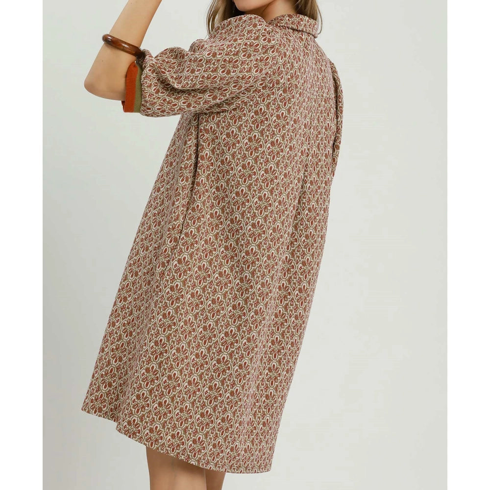 Back view of a woman wearing a chestnut geometric pattern shift dress with half sleeves.