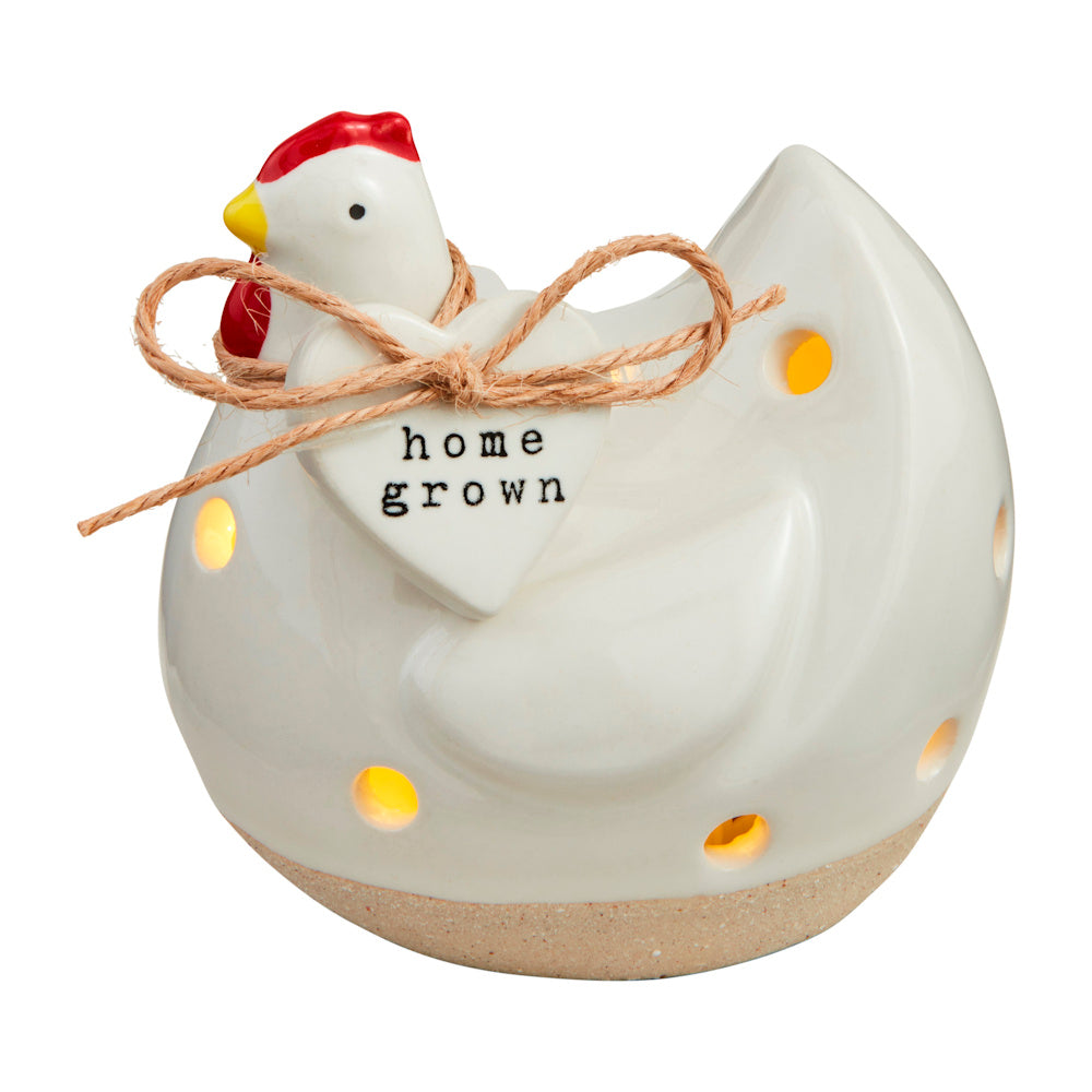 White ceramic chicken light-up sitter with "home grown" heart charm and twine bow, glowing with warm LED light.