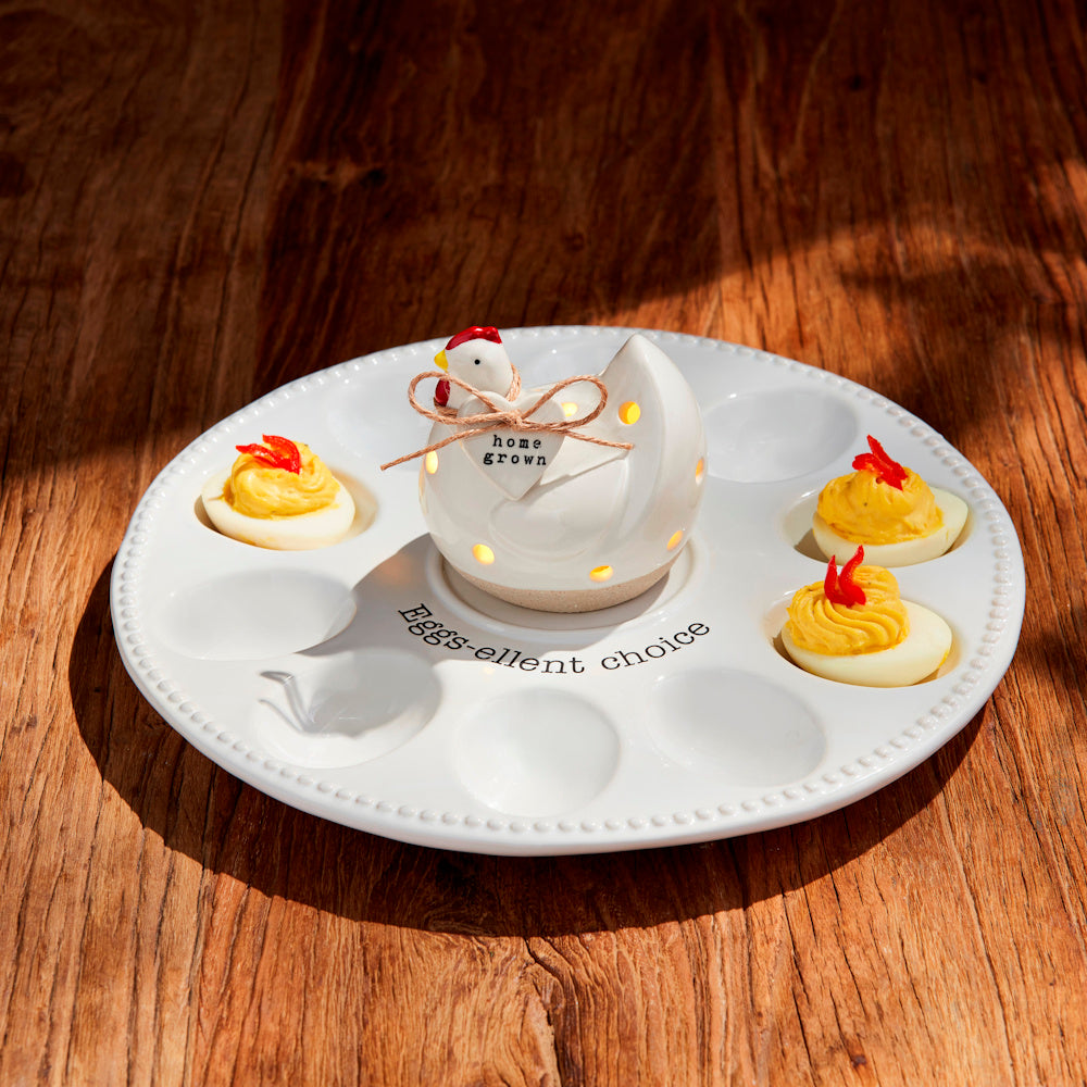 White ceramic chicken light-up deviled egg tray with "Eggs-ellent choice" text and deviled eggs on a wood surface.