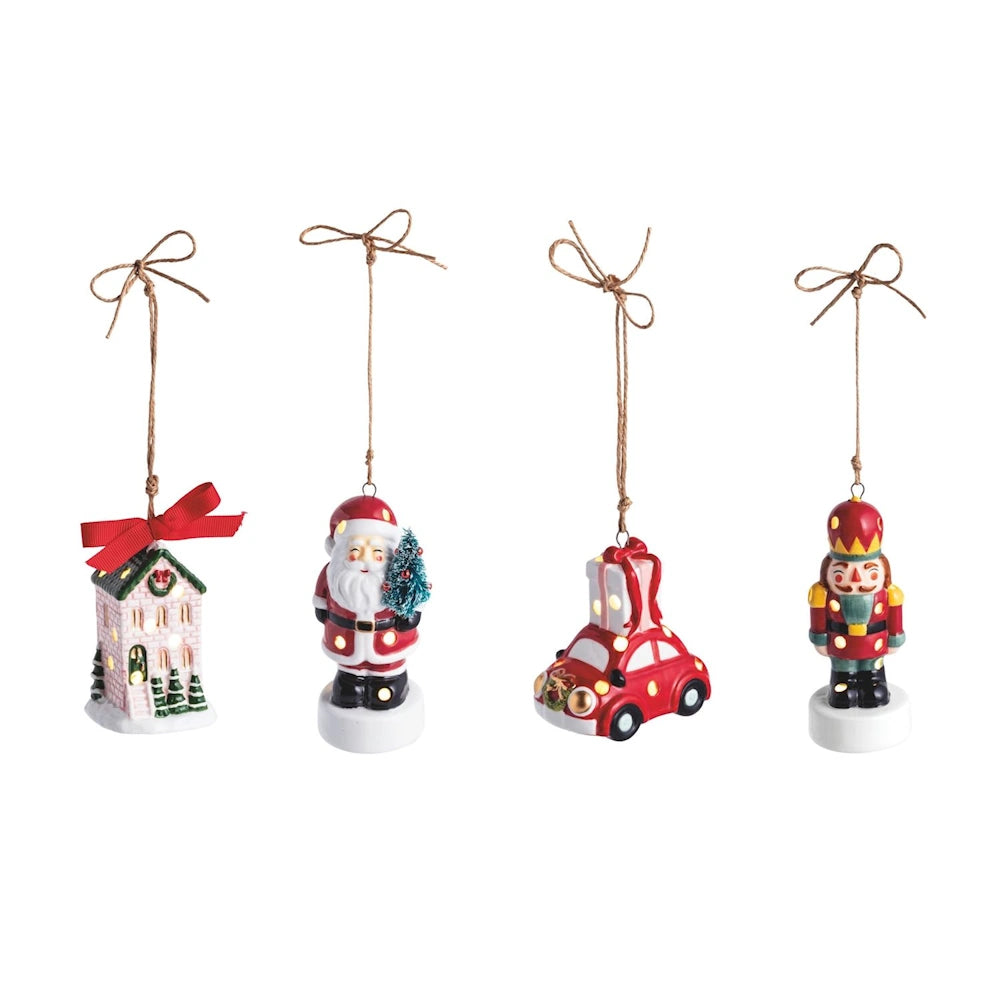 Four ceramic LED Christmas ornaments: a house, Santa Claus, a red car, and a nutcracker.