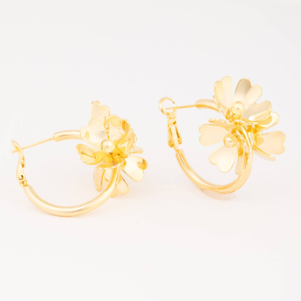 Pair of gold hoop earrings featuring layered floral charms with heart-shaped petals on a white background.