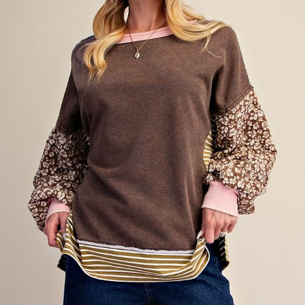 Front view close-up of coffee brown terry knit pullover with floral sleeves and striped hem.