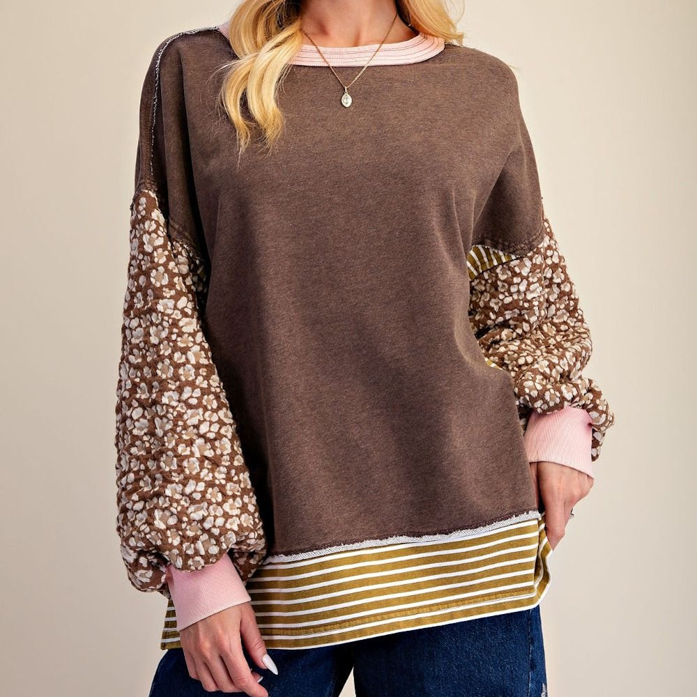 Front view of coffee brown terry knit pullover with floral sleeves and striped hem.