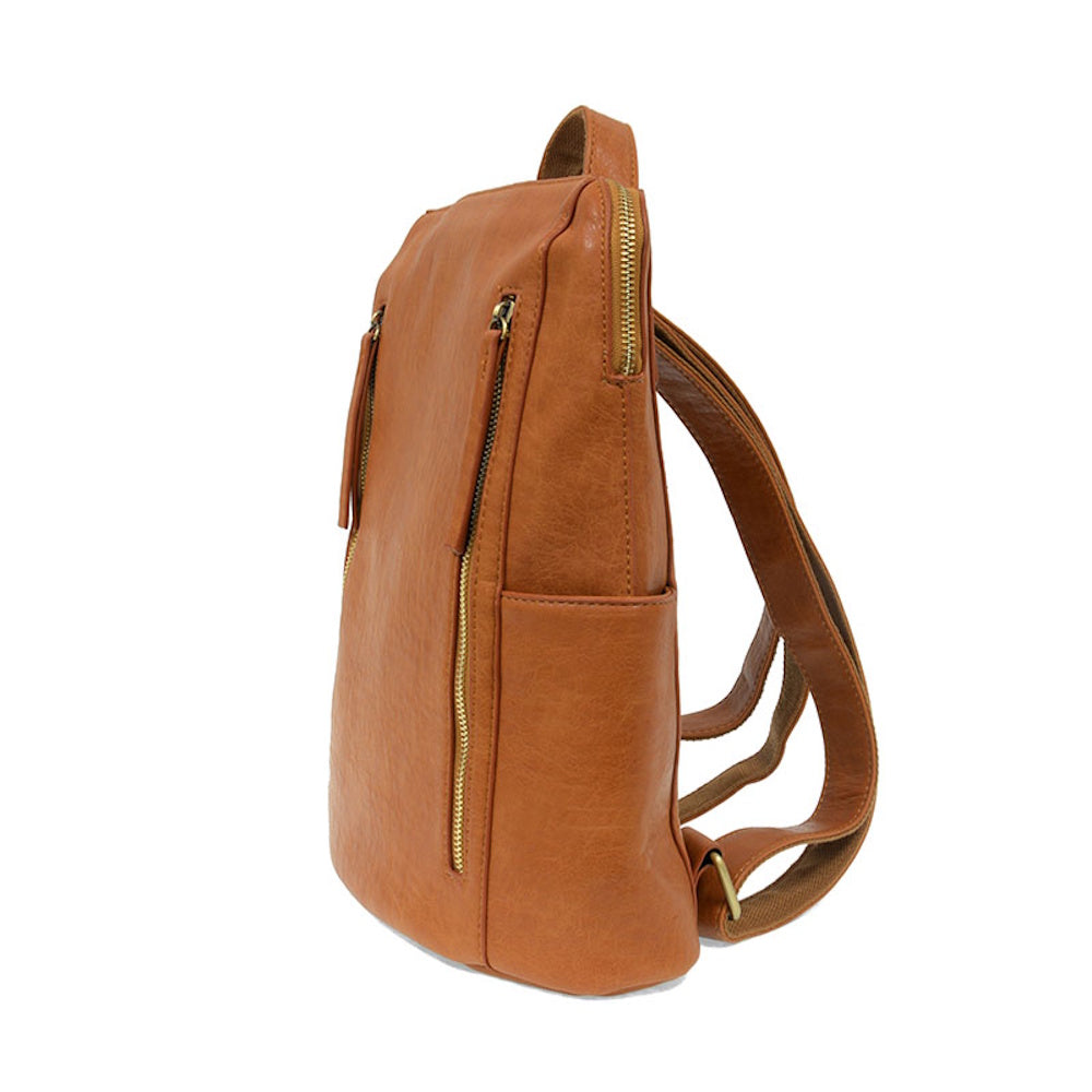 Side view of a cognac faux-leather Raegan backpack featuring double gold zippers and a slim, minimalist profile.