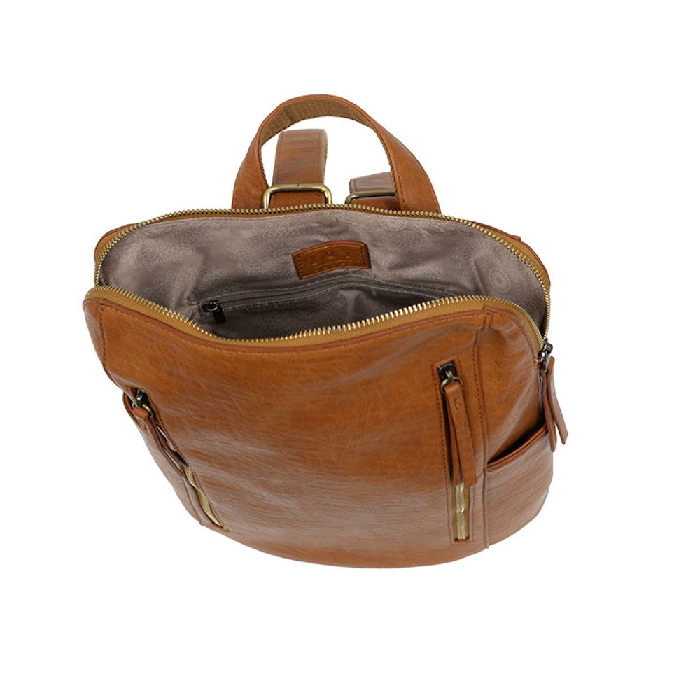 Open interior of a cognac leather backpack with double zippers, patterned lining, and a small zippered pocket.