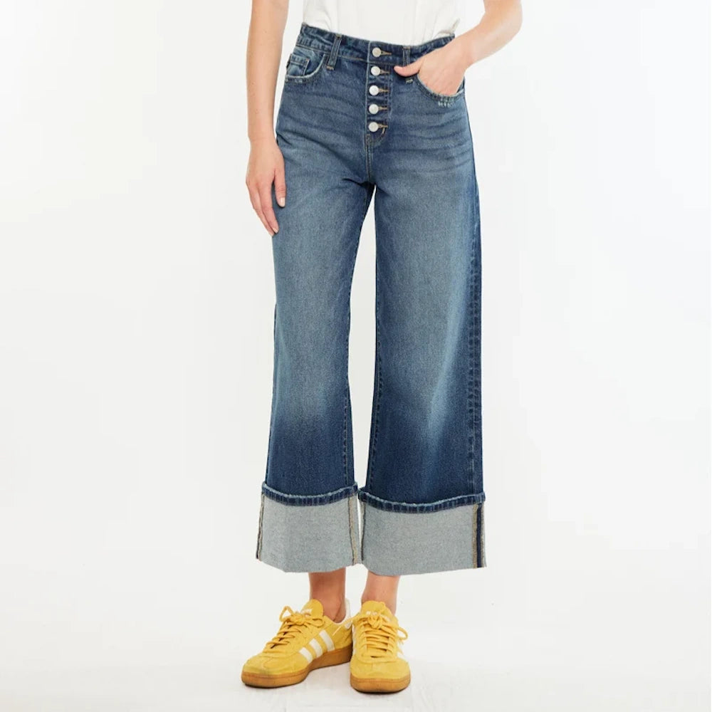 Ultra high-rise wide-leg crop jeans in medium wash with a button fly, large cuffed hems, and yellow sneakers.