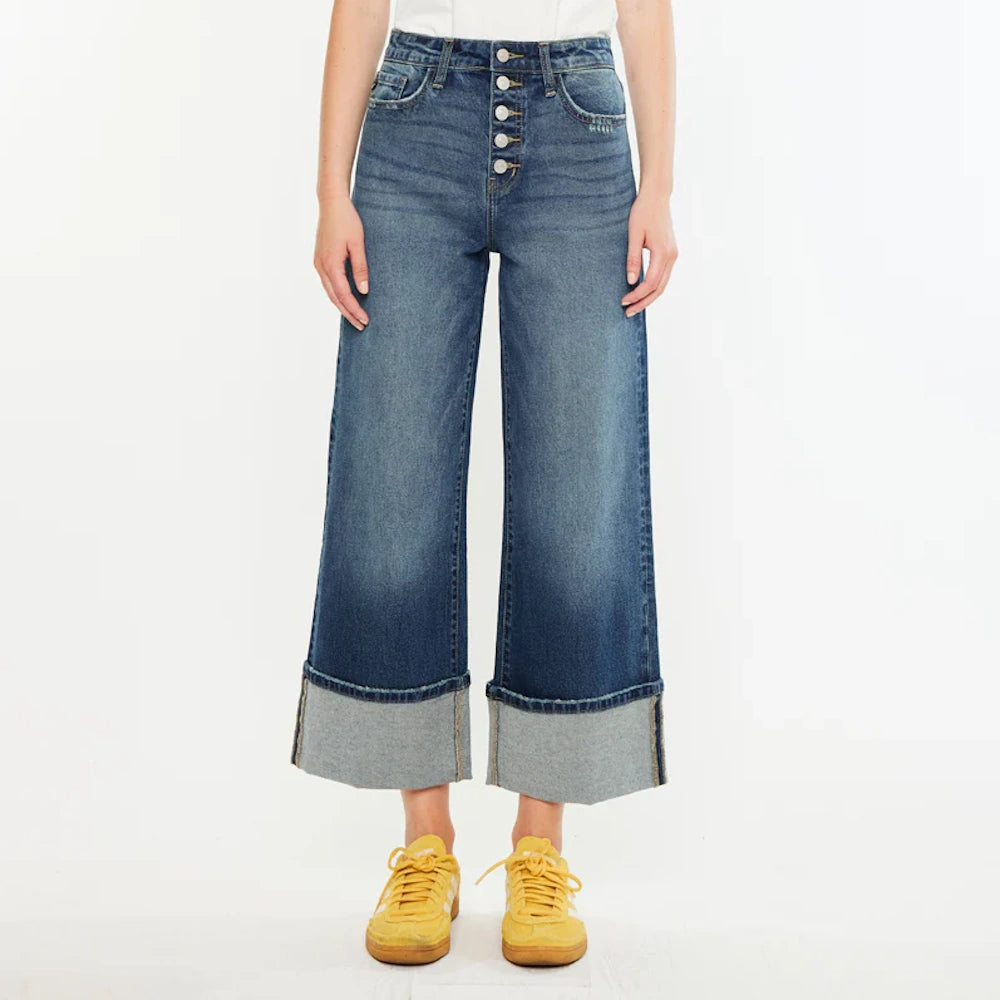 Ultra high-rise wide-leg crop jeans with button fly and wide cuffed hems, styled with yellow sneakers.