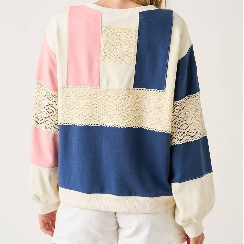 Oversized color-block sweatshirt with pink, navy, and cream panels and lace crochet detailing, back view.