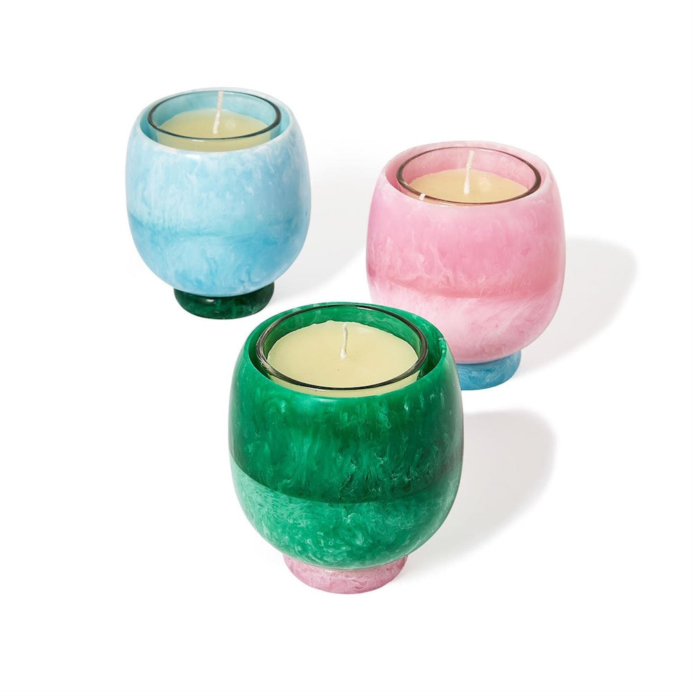 Top-angle view of three color swirl pedestal candle cups filled with scented wax.