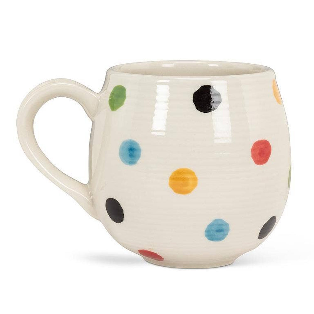 Side view of the white ceramic polka dot mug on a white background.