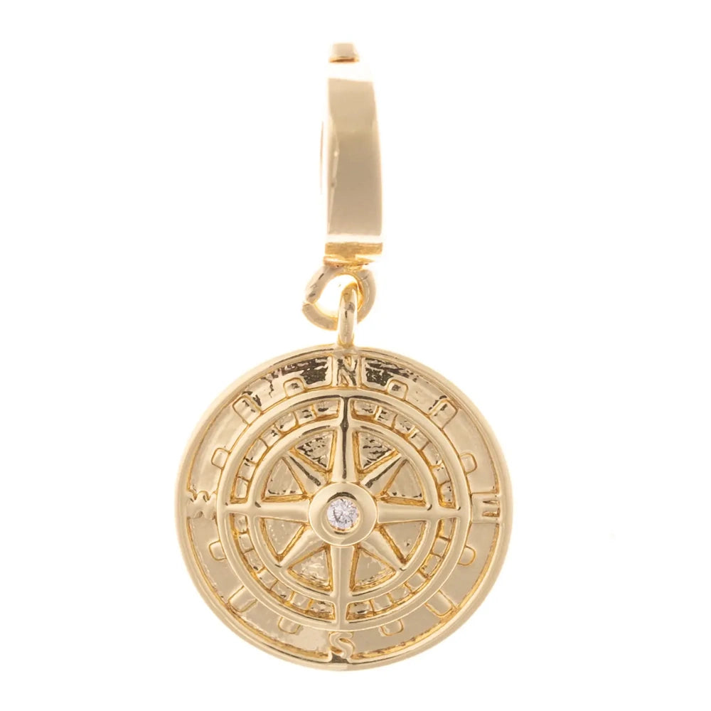 Gold circular compass pendant charm featuring a crystal center accent on a white background.