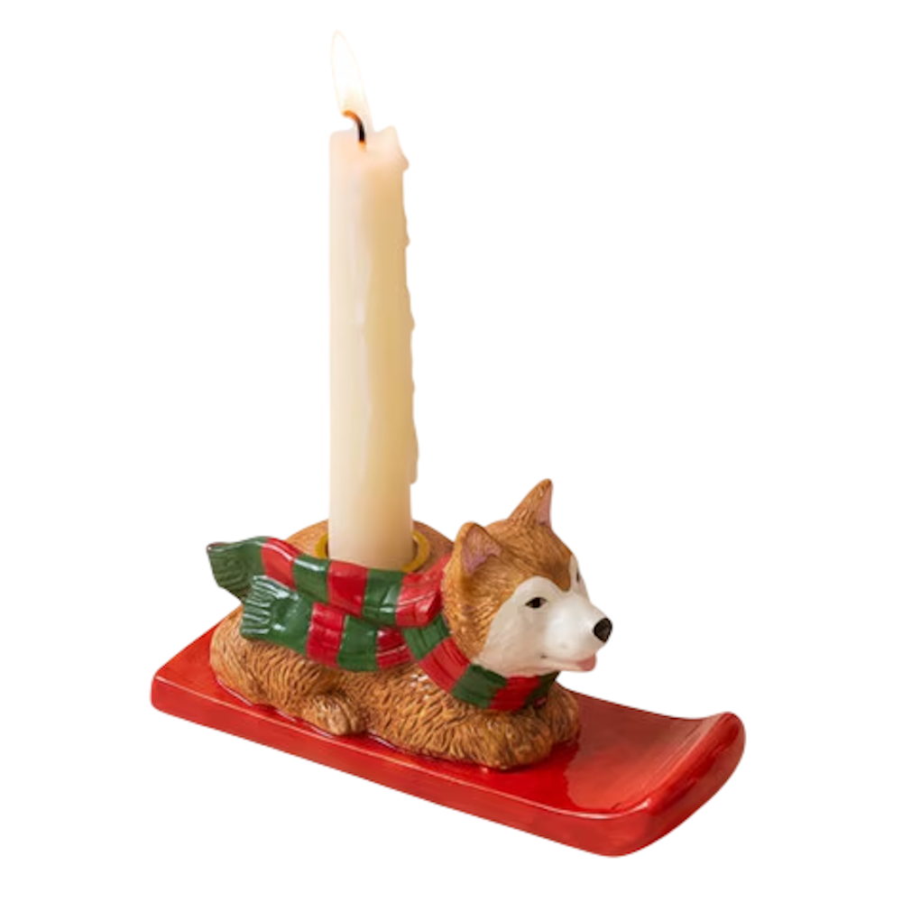 Ceramic corgi taper candleholder wearing a red and green striped scarf on a red sled.