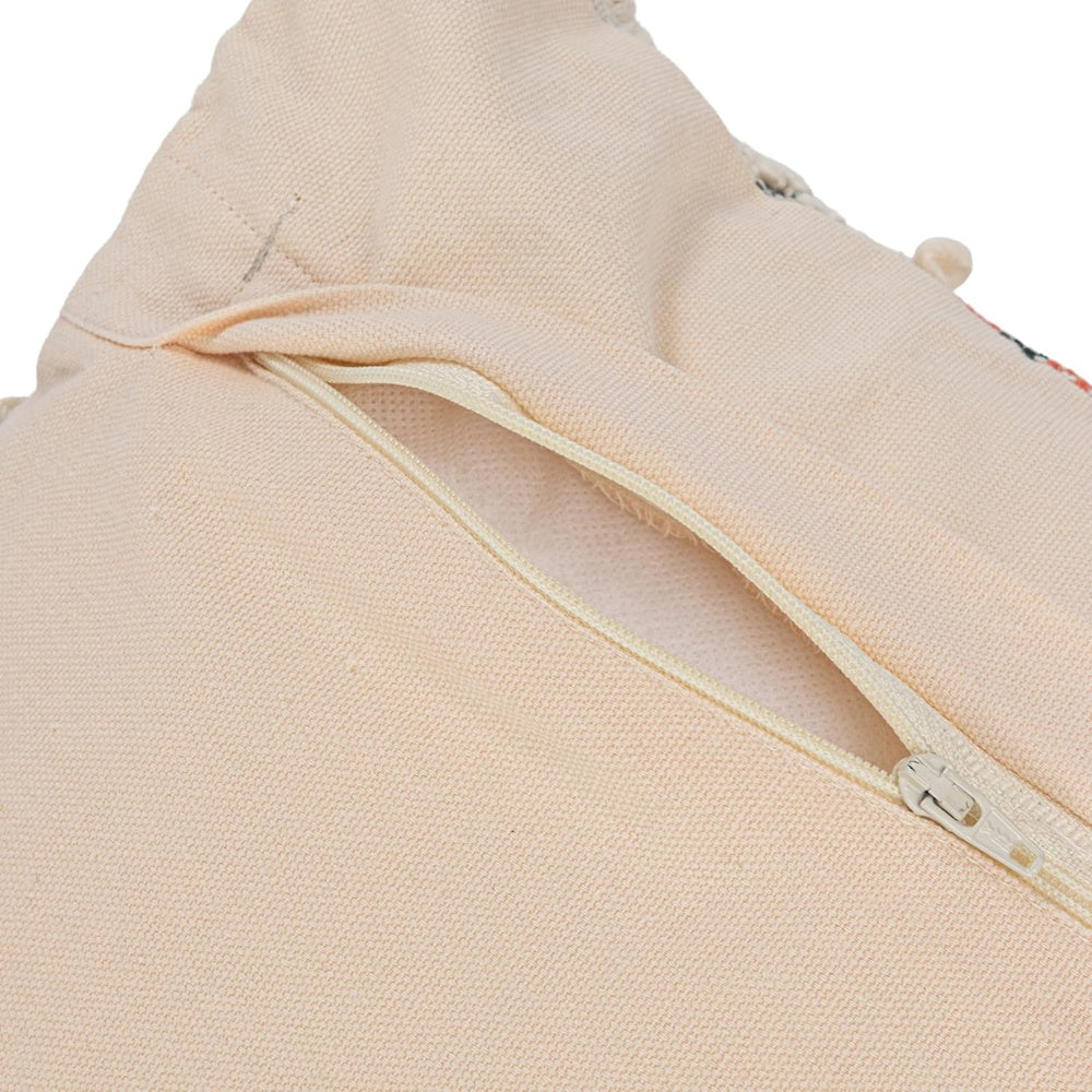 Close-up of a beige canvas pillow cover featuring a durable hidden zipper closure for easy cushion insertion.
