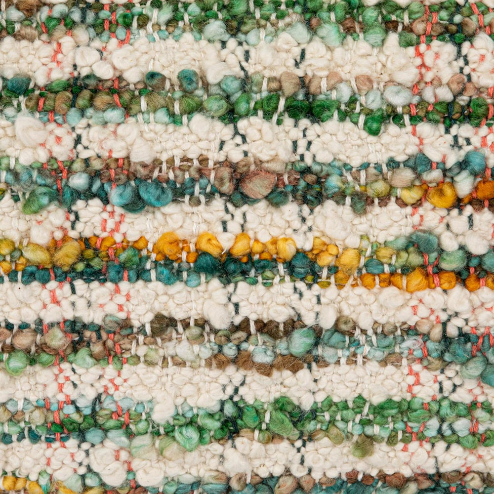 Close-up of bohemian style woven textile featuring thick wool loops in earth tones and vibrant green.