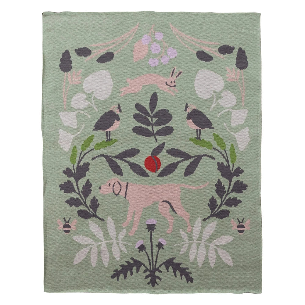Sage green cotton knit baby blanket featuring pink animals, birds, and botanical patterns for a nursery.