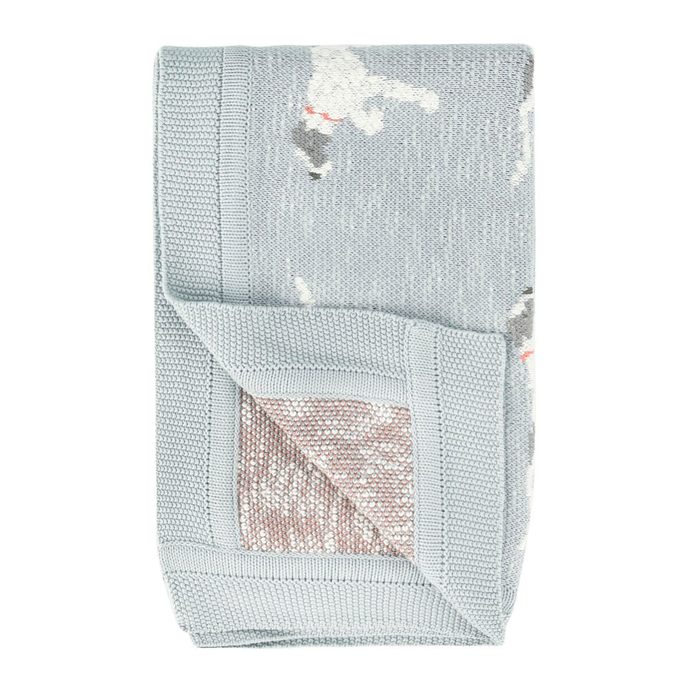 Folded light blue cotton knit baby blanket featuring a white dog pattern and a textured knit border.